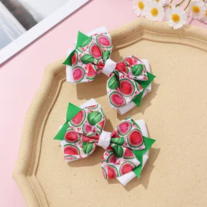 Close-up of double-layered bow hair clips with fresh watermelon patterns on a pink background