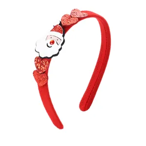 Dettaglio cerchietto natalizio rosso con Babbo Natale e cuori glitterati decorativi