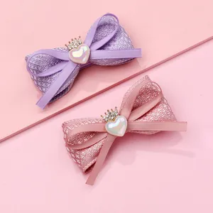 Détail de barrettes à nœuds en tissu faites main avec couronnes et cœurs brillants