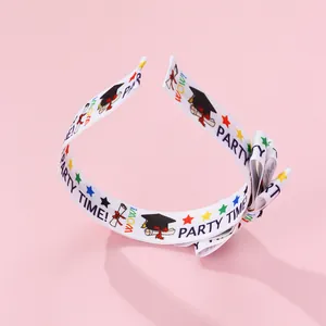 Close-up of double-layered ribbon headband with graduation patterns and party text
