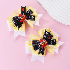 Détail de pinces à cheveux nœuds thème école avec motifs ABC et mini livres