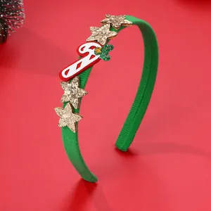 Dettaglio del cerchietto natalizio verde con stelle di paillettes oro e bastoncino di zucchero
