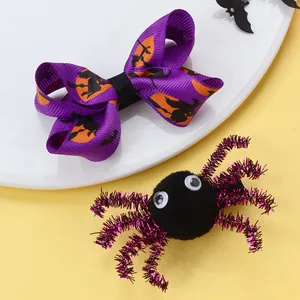 Detail von Halloween-Haarspangen mit lila Hexenschleife und schwarzer Spinne auf Gelb