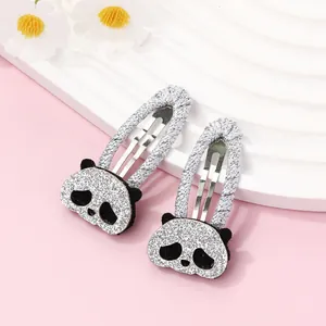 Close-up of glittery panda hair clips with silver woven bases and cartoon embroidery