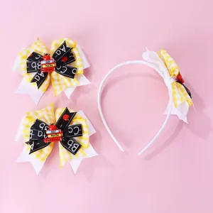 Detail view of yellow plaid school-themed bow headband and clips with mini book charms