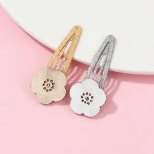 Detailed view of sparkly gold and silver flower hair clips with crystal centers