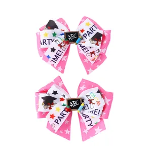 Détail de barrettes nœuds rose et blanc thème école avec tableau ABC et étoiles
