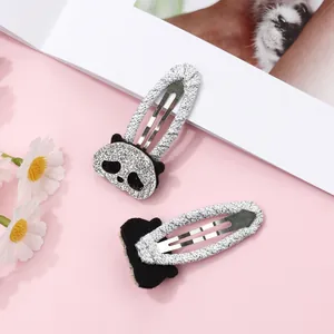 Close-up of cute panda BB hair clips with glitter embroidery and fabric wrapping