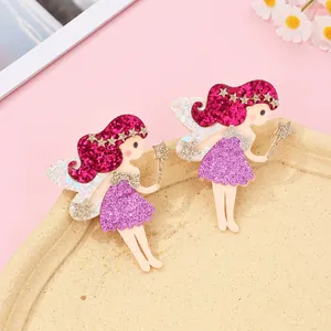 Détail de barrettes féeriques avec cheveux rouges pailletés et robe à paillettes violette