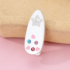 Detail of sweet heart hair clip with colorful rhinestones on a beige stand