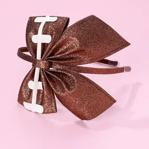 Sparkly brown American football bow headband with glitter texture on pink background