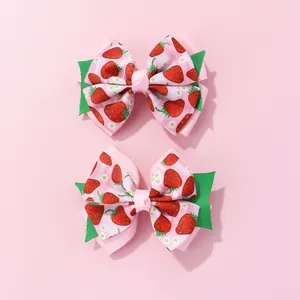Detail of layered strawberry bow hair clips with cute fruit patterns for girls