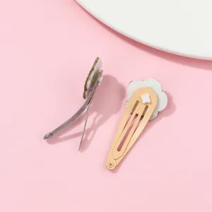 Detail view of white flower hair clips featuring duckbill and snap BB clip mechanisms