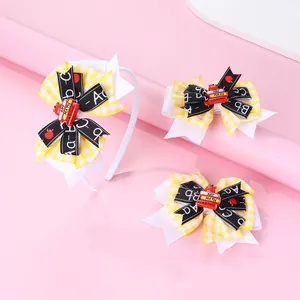 Detail of yellow plaid bows and book stack resin charm on school hair accessory set