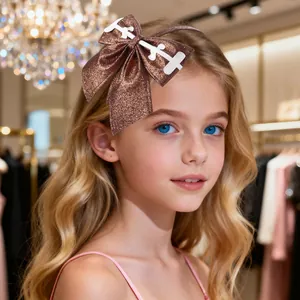 Detail of brown glitter bow headband featuring a stylish white decorative emblem
