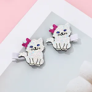 Pair of glitter cat hair clips with blue rhinestone eyes and pink sequin bows for kids