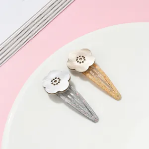 Detail of glitter BB hair clips with textured floral motifs for children and girls