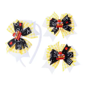 Detail of school-themed hair bow set with checkered patterns and miniature book charms