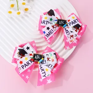 Détail de barrettes de remise des diplômes roses et blanches avec tableau ABC