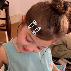 Detail shot of a young girl wearing two silver glitter panda hair clips on her hair