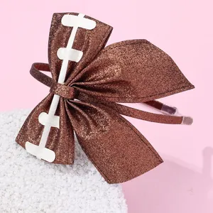 Detail of brown glitter bow headband with white bone patch on pink background