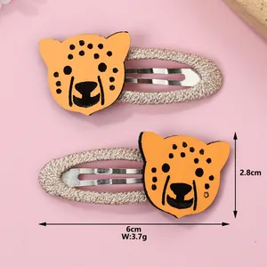 Détail des barrettes léopard de 6 cm avec dimensions sur un fond rose poudré