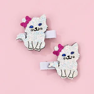 Detail of white glitter cat hair clips with pink bows and blue gemstone eyes