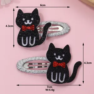 Detail showing dimensions of black glittery cat hair clips with red bows and silver clips