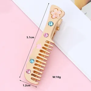 Detail view of gold alloy comb hair clip with pink flower and colorful crystals, 5.1cm