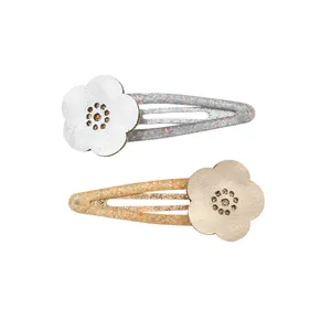 Close-up of glittery hollow flower hair clips in gold and silver finish