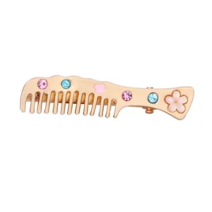 Champagne gold comb hair clip with pink flowers and colorful rhinestones on white background