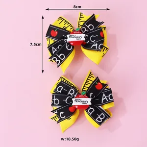 Détail de nœuds à cheveux pour enseignants avec décor de pomme et motifs d'école