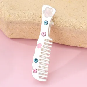Detail of silver alloy comb hair clip with pink flowers and colorful crystals