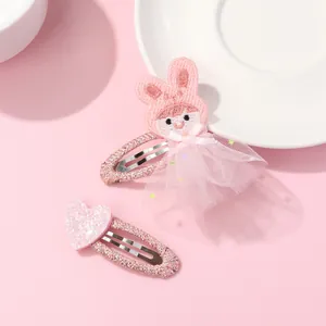 Barrettes roses pour filles avec cœur pailleté et lapin en tulle sur une assiette blanche