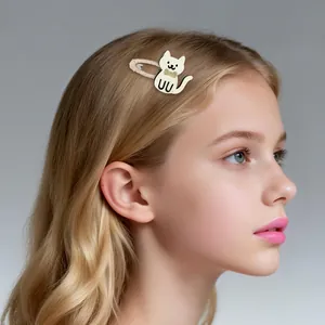 Detail of white cartoon cat hair clip with gold glitter bow worn on blonde hair