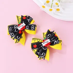 Détail de nœuds pour cheveux thème enseignant avec ruban règle et décor pomme rouge