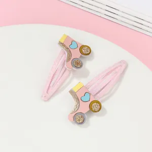 Detalle de pinzas para el pelo con purpurina rosa en forma de patines de hielo