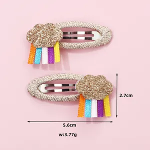 Detail showing rainbow hair clip dimensions of 5.6cm by 2.7cm and sparkling cloud design