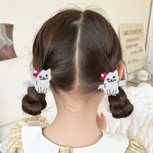 Detail view of cute cat-shaped hair clips with white sequins on a young girl's hair