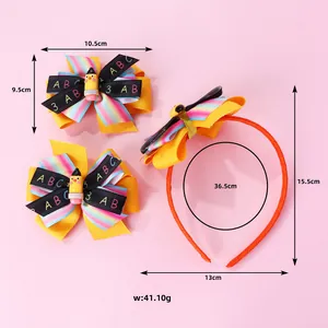 Detail of yellow school-themed bow headband and hair clips with pencil decor and ABC print