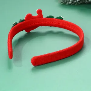 Dettaglio del cerchietto natalizio in peluche rosso con elementi decorativi seghettati