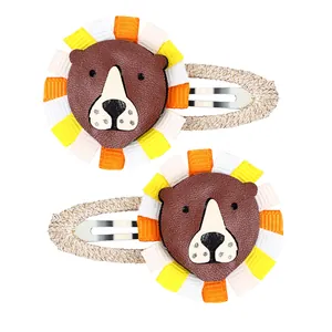 Detail of handmade cartoon lion hair clips with brown faux leather and colorful ribbons