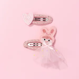 Détail de la pince à cœur pailleté rose et poupée lapin en tulle avec étoiles