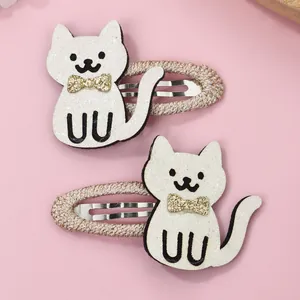 Detail of glitter cat hair clips with gold sequin bows and fabric wrapped metal grips
