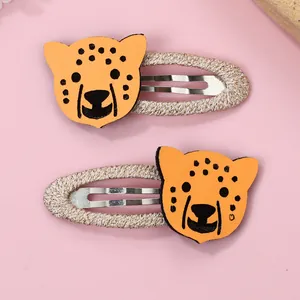 Détail de jolies barrettes BB imprimé léopard jaune pour coiffure d'enfant
