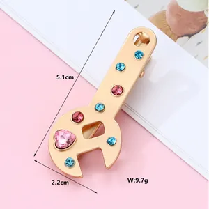 Detailed size view of creative wrench hair clip with colorful rhinestones in gold finish