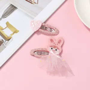 Détail d'une barrette cœur rose pailletée et épingle à cheveux lapin en tulle pour filles