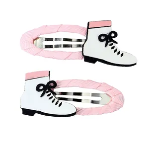 Detalle de pinzas de pelo con forma de patines rosa y blanco con lentejuelas