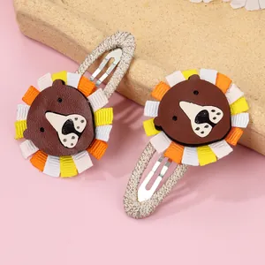 Pair of handmade cartoon lion hair clips with brown leather and colorful ribbon details