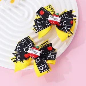 Détail d'une barrette à cheveux nœud avec motif règle et pomme Happy Teacher's Day